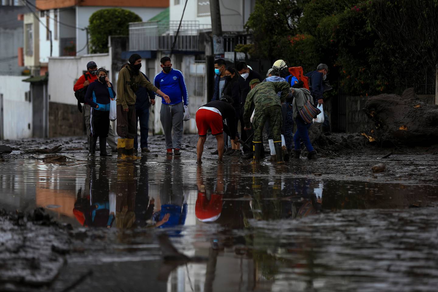Aluvión en La Gasca AME2567. QUITO (ECUADOR), 01/02/2022.- Vista de personas mientras ayudan en la labor de limpieza hoy sobre el lodo ocasionado por las lluvias del día anterior, que afectó algunos barrios del oeste de la capital ecuatoriana y que causó al menos 18 víctimas mortales, según han informado las autoridades hoy en Quito (Ecuador). A 18 ascendió el número de personas fallecieron el lunes tras un aluvión que afectó a varios barrios del oeste de la capital ecuatoriana, ciudad que fue azotada por un fuerte aguacero, con récord de precipitaciones, según han informado las autoridades. EFE/José Jácome (Jose Jacome/EFE)